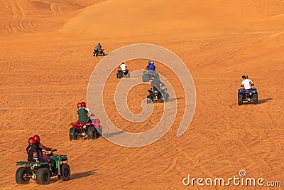 Quad Biking Dubai Adventure Tour â€“Tourists having fun on Quad Bike Riding in dunes of Dubai. Stock Photo